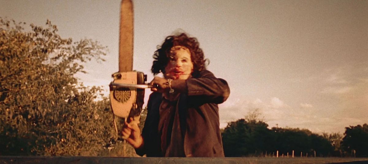 Leatherface chasing after a truck while wielding a chainsaw.