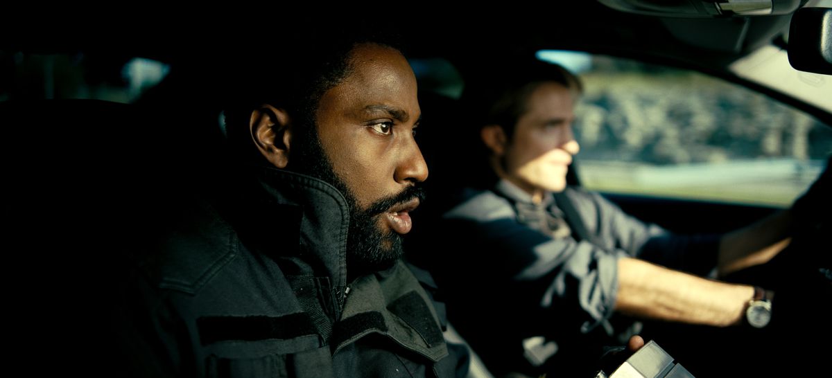 John David Washington and Robert Pattison sit in a car in Tenet