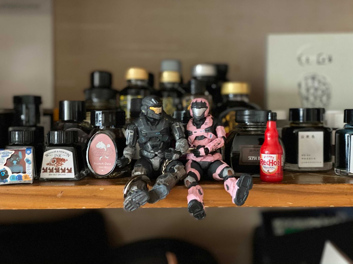 Two Spartan action figures from Halo Reached sitting on a shelf, handcuffed together.