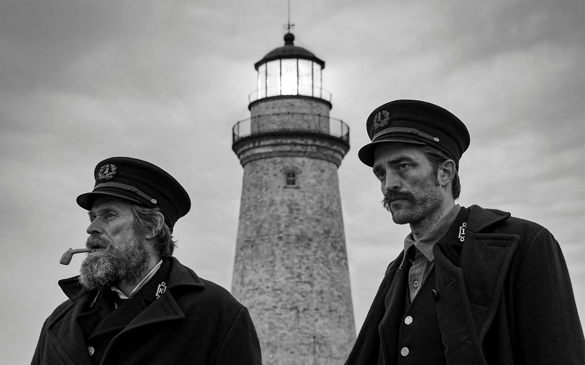 Thomas (Willem Dafoe) and Ephraim (Robert Pattinson) in front of the lighthouse.