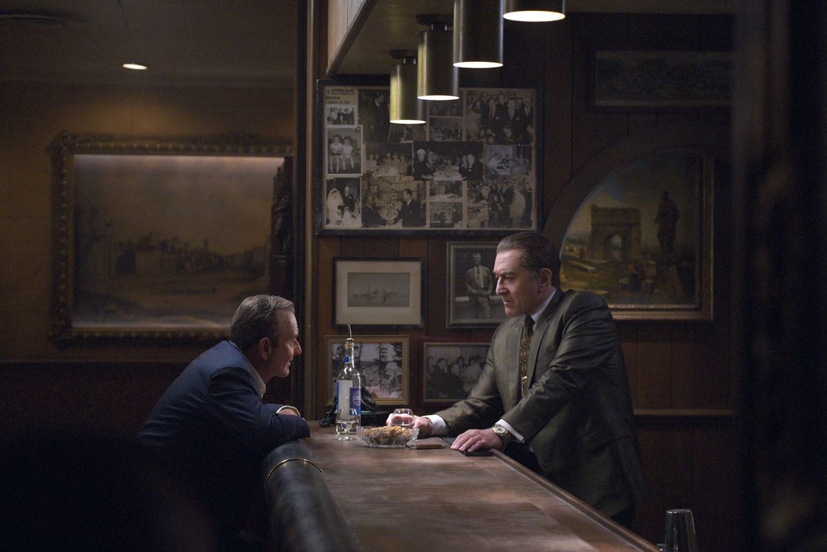 Pacino as Jimmy Hoffa and De Niro as Frank Sheeran across from each other at a bar in The Irishman