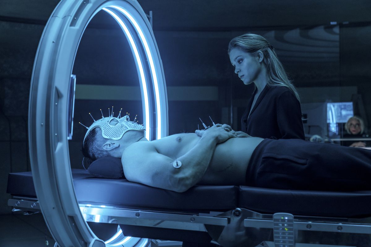 Okay, you got me on this one. Uh, a shirtless Mark Wahlberg is lying on his back on what looks like a hospital bed, wearing a mesh face mask covered with spikes topped with LEDs? And his head is through some kind of big ring lined with blue florescent lights? And Sophie Cookson is looking on a little judgmentally? Anyway, this happens in Infinite.