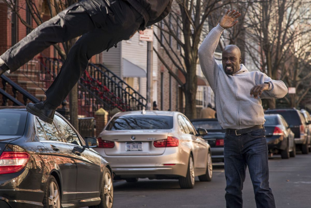 Luke Cage throws a bad guy in the street