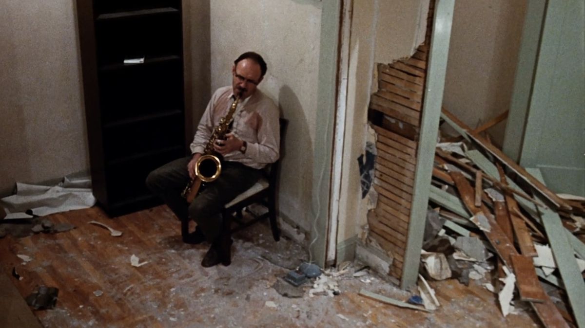 Gene Hackman as Harry Caul forlornly playing the saxophone in a ransacked apartment in The Conversation