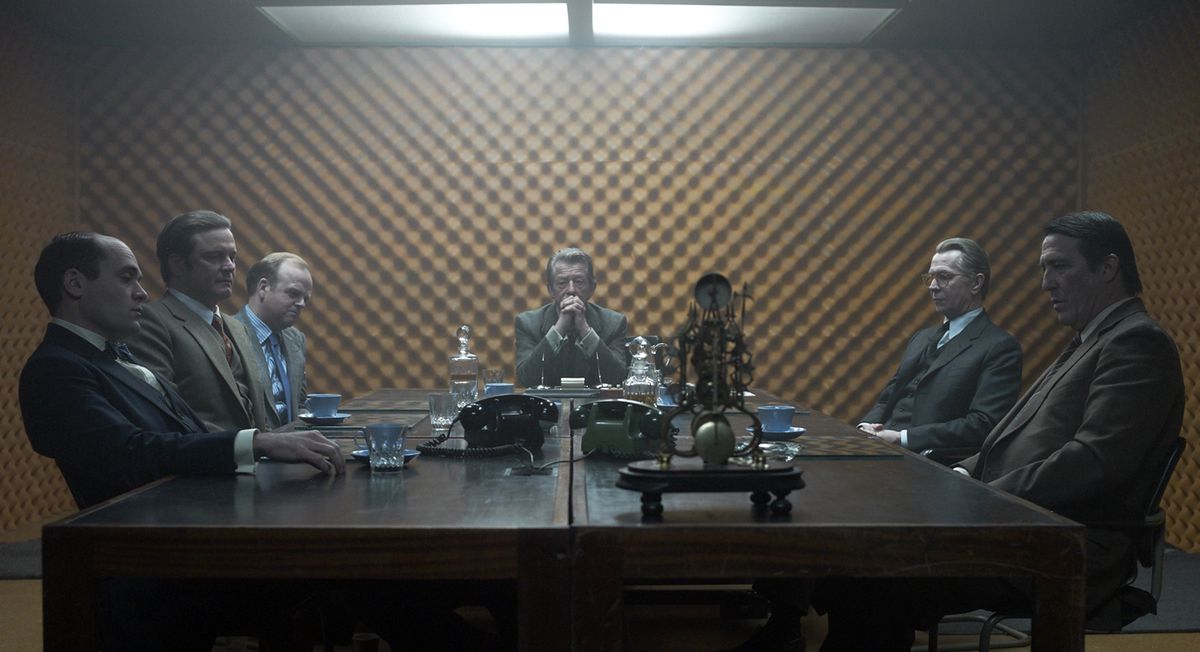 Some of the cast of Tinker Tailor Soldier Spy seated around a table.