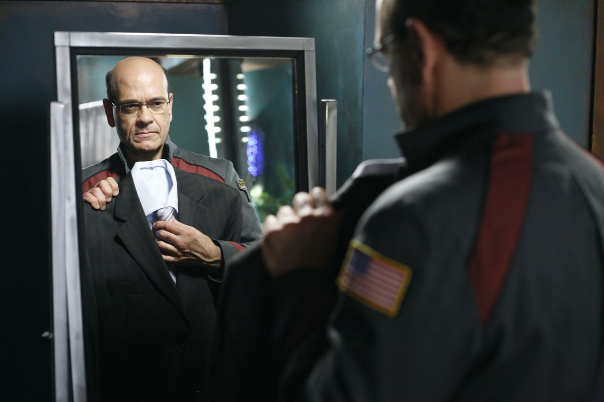Robert Picardo on Stargate Atlantis holding a suit up in front of a mirror
