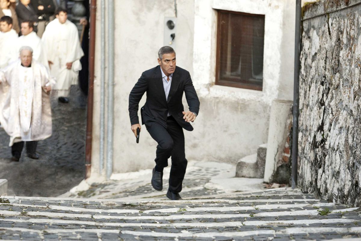 george clooney runs up stairs in rome in The American