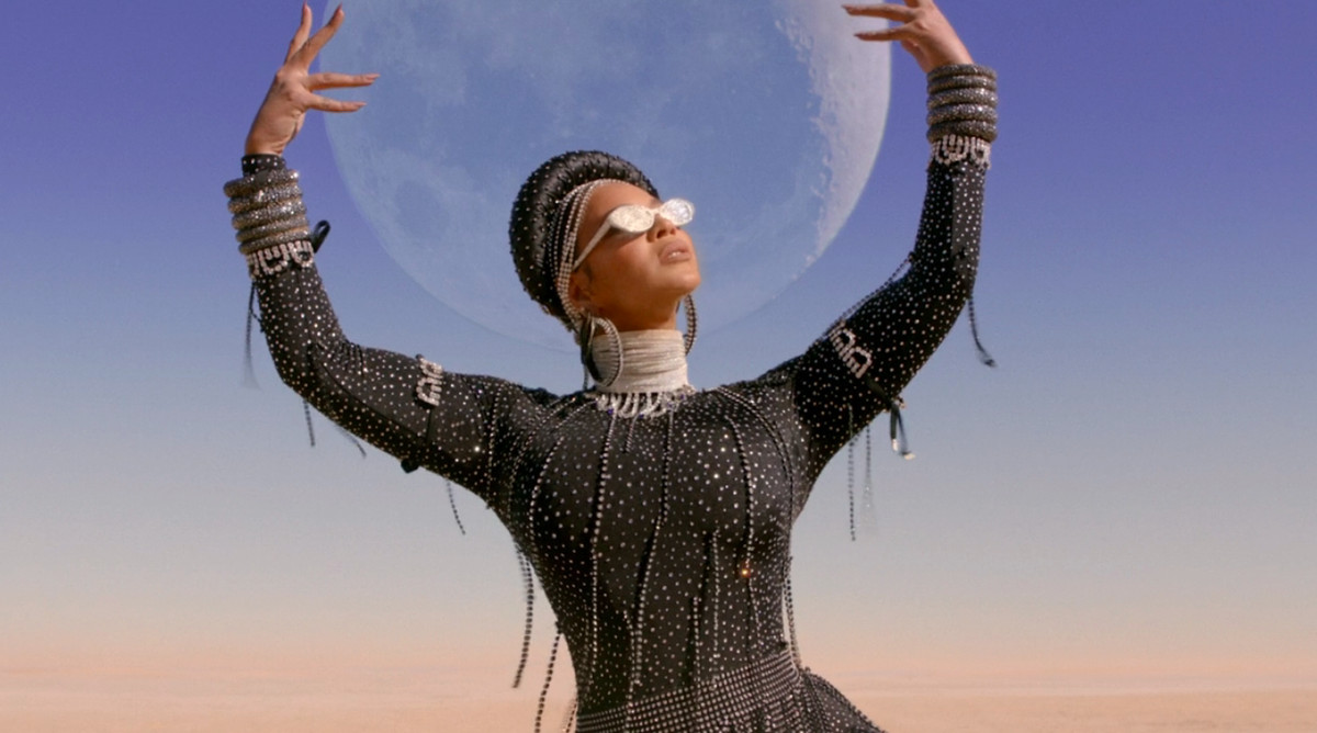 Beyonce in Black Is King, holding up the moon in a desert
