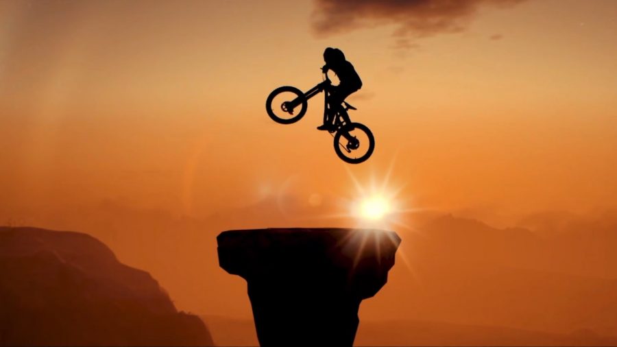 A cyclist hopping up above a rocky platform