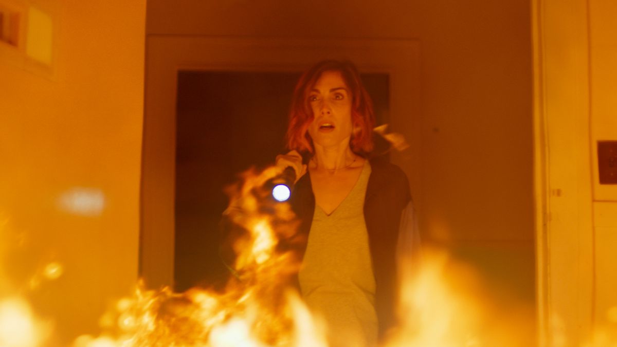 Carly Pope in Demonic standing in a burning room