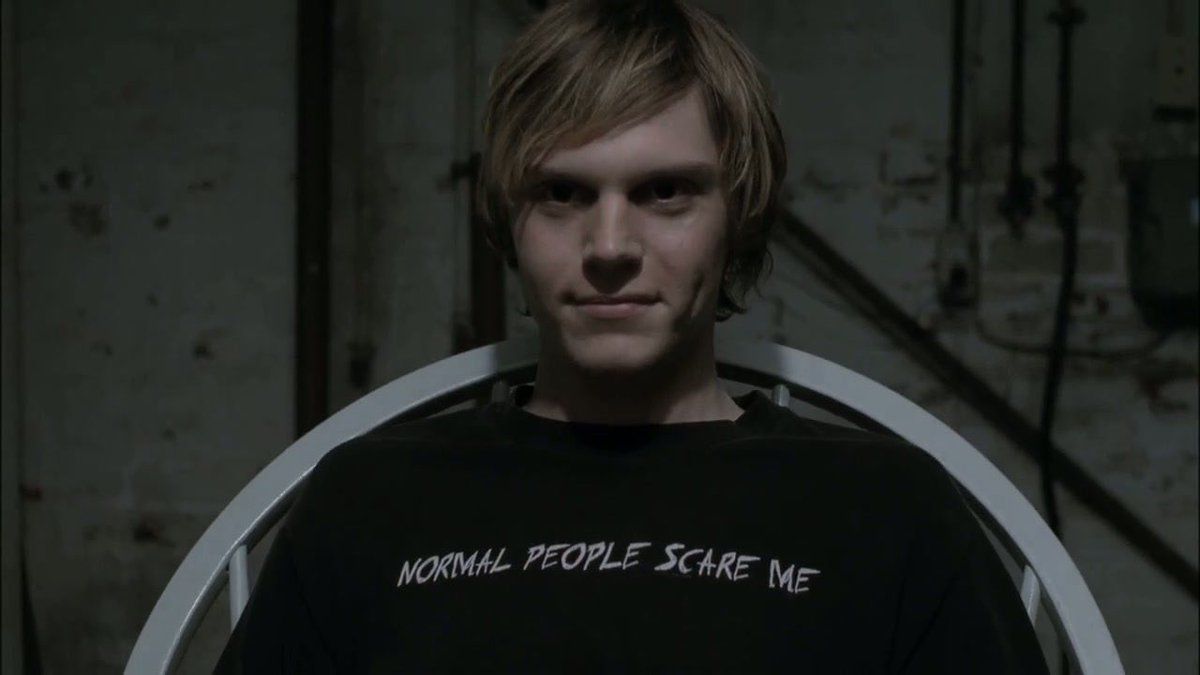 a blonde teenage boy in a black t shirt, he looks evil in American Horror Story