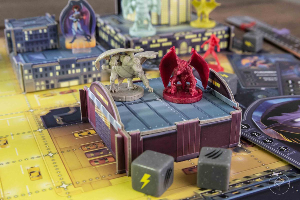 Two Gargoyles miniatures on top of a warehouse, about one inch off the game board.