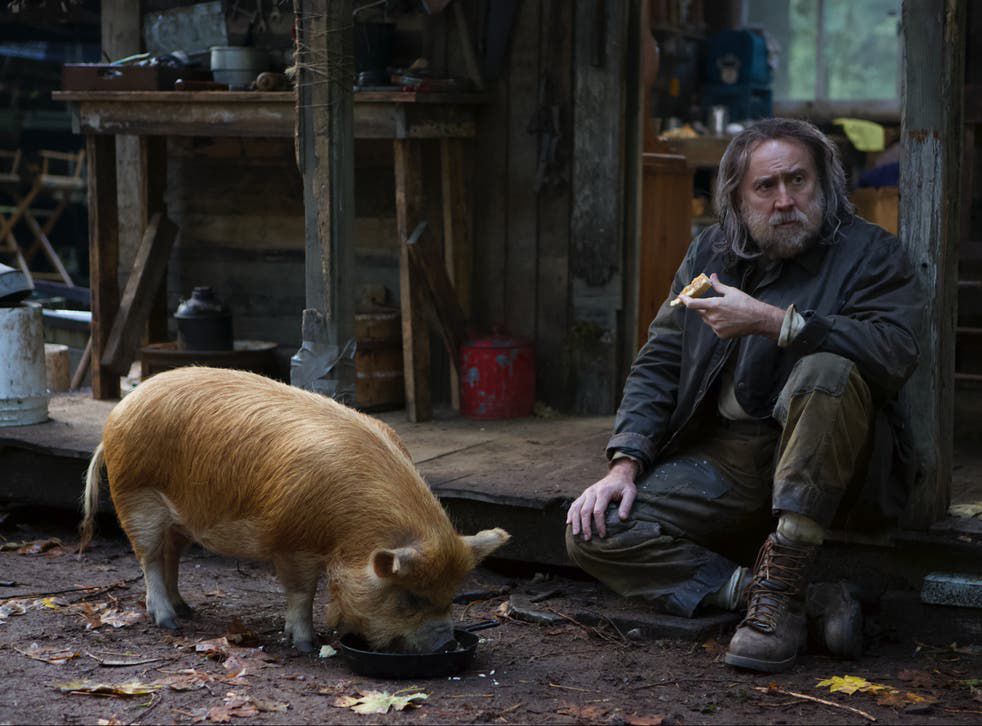 Nicolas Cage as Rob, the truffle-hunting hermit, eating breakfast with his prized pig in Pig.