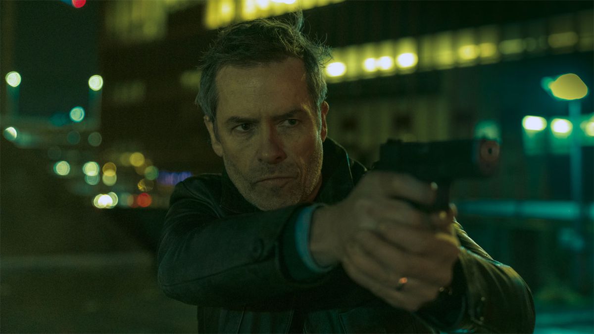 Guy Pearce as David Carmichael aiming a pistol in Zone 414.