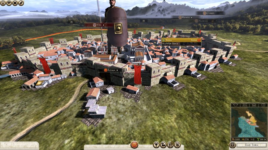 a shot of a giant man, representing an army, standing on top of a miniature town on the campaign map.