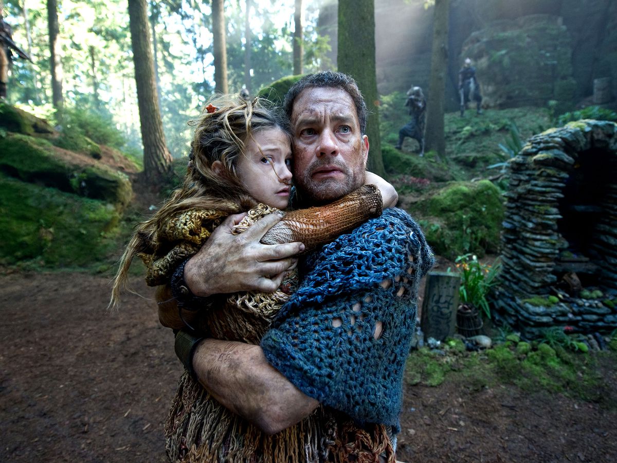 Zachry (Tom Hanks) clutching a child to him while surrounded by marauders in Cloud Atlas.