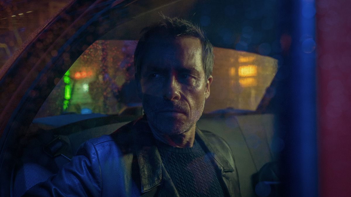 Guy Pearce scowls from a multicolored booth in Zone 414